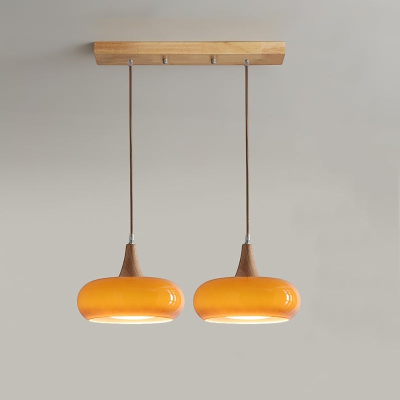 Lumiris suspension 2 abat-jours verre ambré et bois, style moderne, lumière ambiante chaleureuse.